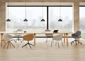 Mesa de reuniones larga con sillones tapizados en tonos claros y marrón ante grandes ventanales