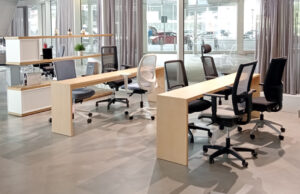 Puestos de trabajo con sillas operativas de distintos modelos y mueble divisorio de madera