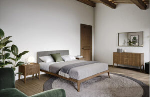 Dormitorio rústico con vigas de madera, cama con cabecero gris y cómoda de nogal