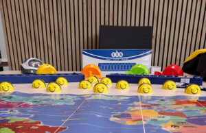 Fila de robots Bee-Bot sobre un tapete con el mapa del mundo
