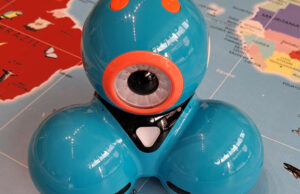 Primer plano del robot Dash azul sobre un tapete con un mapa
