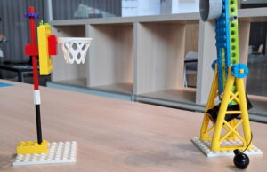 Construcciones LEGO de una canasta y una grúa sobre la mesa del taller