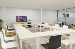 Sala de formación con mesas en U, sillas blancas, amarillas y negras y televisor