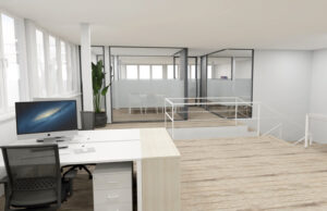 Puesto de trabajo junto a ventanales con vistas a la zona acristalada y la escalera