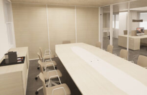 Sala de juntas con mesa larga de madera clara, sillas beis y mueble office con cafetera