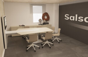 Sala de reuniones con mesa clara, sillas beis, pantalla y pared con el logotipo