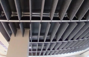 Techo con bafles acústicos verticales de fieltro gris vistos desde abajo