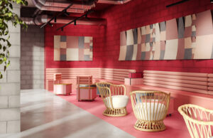 Sala de espera con paneles acústicos sobre pared roja y butacas de fibra natural
