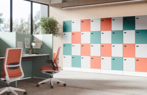 Pared de taquillas en blanco, coral y verde agua junto a puestos con sillas naranjas