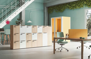 Taquillas de madera y blancas junto a una cabina amarilla, con pared verde y escalera