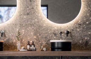 Encimera de baño de piedra con lavabo negro y espejos circulares retroiluminados