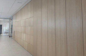 Pasillo con revestimiento de madera clara de listones verticales y puertas integradas