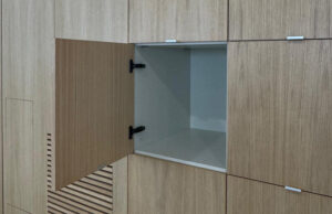 Armario de madera con una puerta abierta que muestra el interior claro y la rejilla inferior