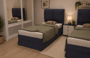 Habitación con dos camas individuales de cabecero azul, mesilla blanca y armario con espejo